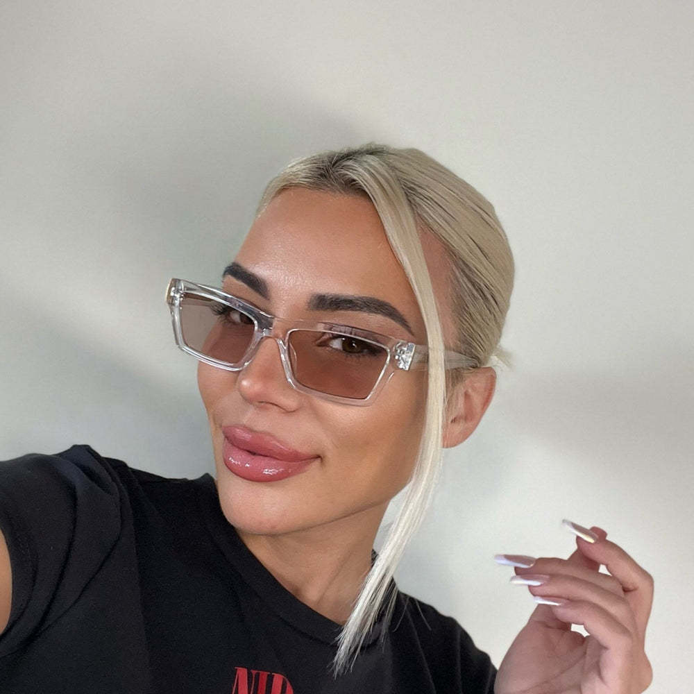 customer content - _caseyjordann  wearing dime optics laurel cat eye sunglasses with a translucent clear frame and rose pink with gold flash lenses front view