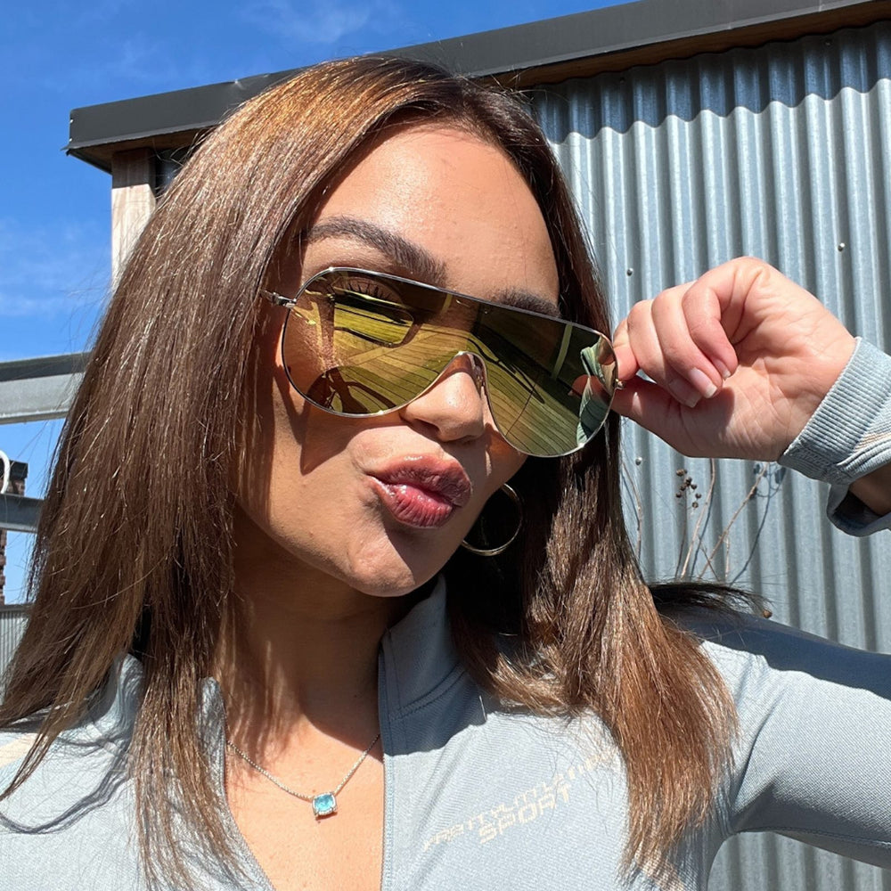 customer content - thealexaofficial  wearing dime optics tarzana shield sunglasses with a brushed gold metal frame and gold mirror polarized lenses front view