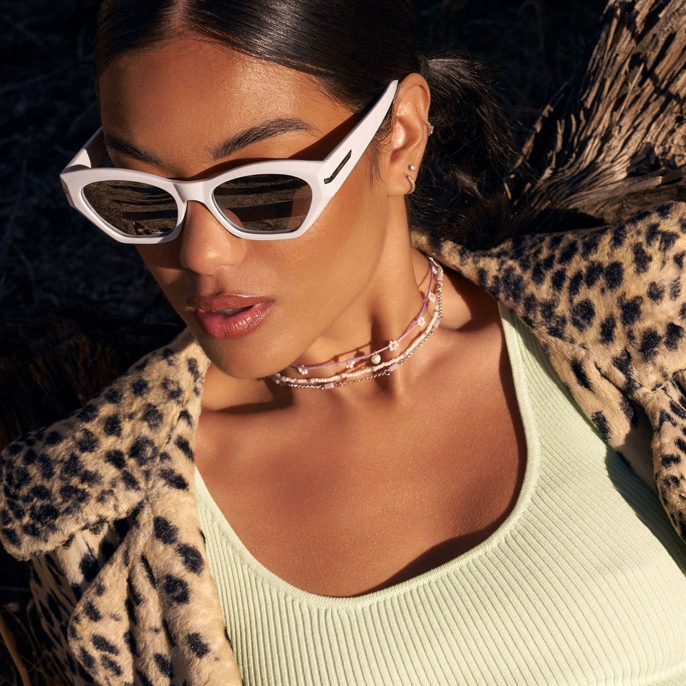 on model - female wearing dime optics sawtelle cat eye sunglasses with a glossy white frame and silver mirror polarized lenses detailed view