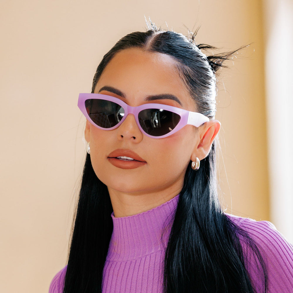 lifestyle - les do makeup wearing last call cat eye sunglasses with a lavender fog crystal frame and solid grey polarized lenses close up view