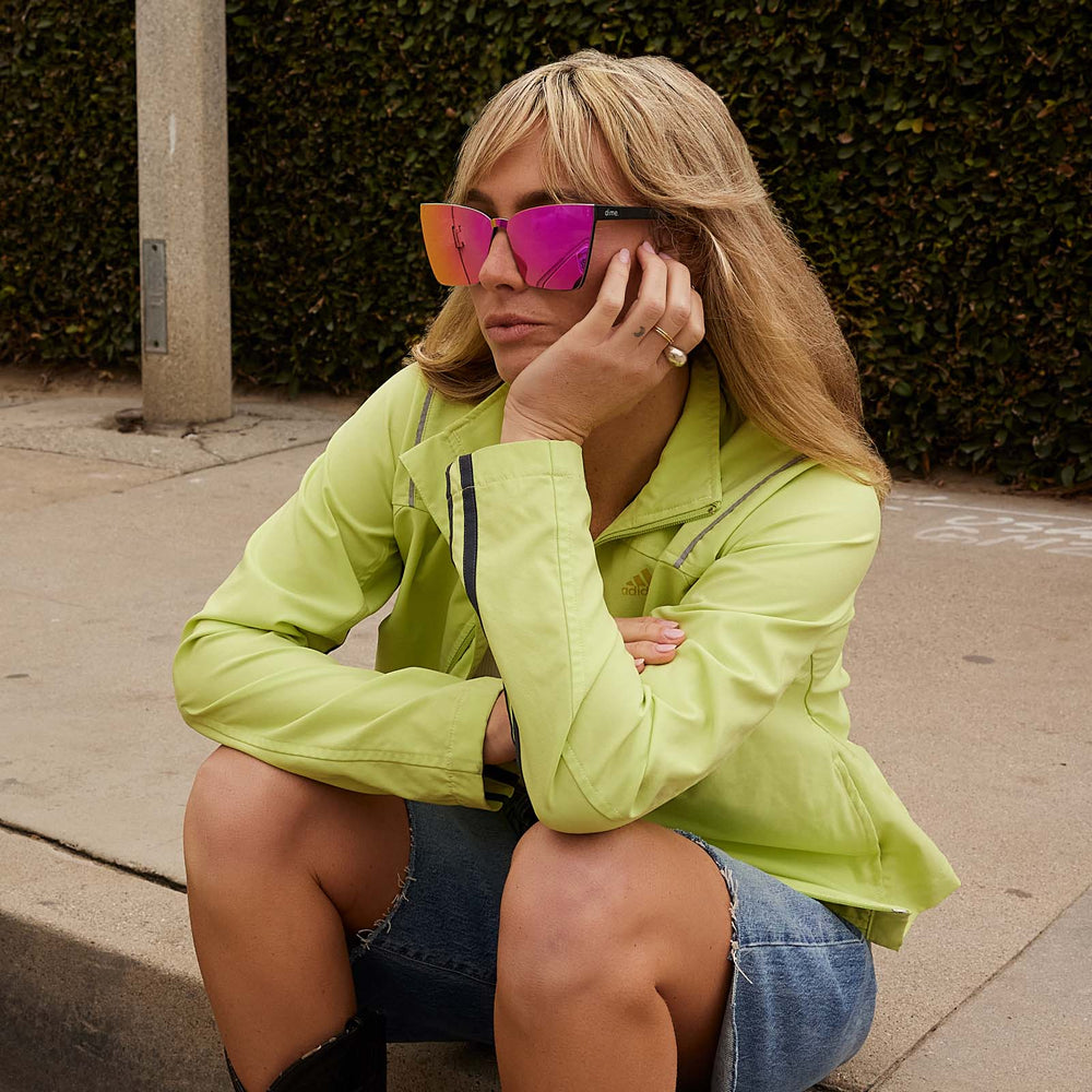 on model - female wearing dime optics glendale cat eye sunglasses with a black frame and candy pink mirror lenses angled view