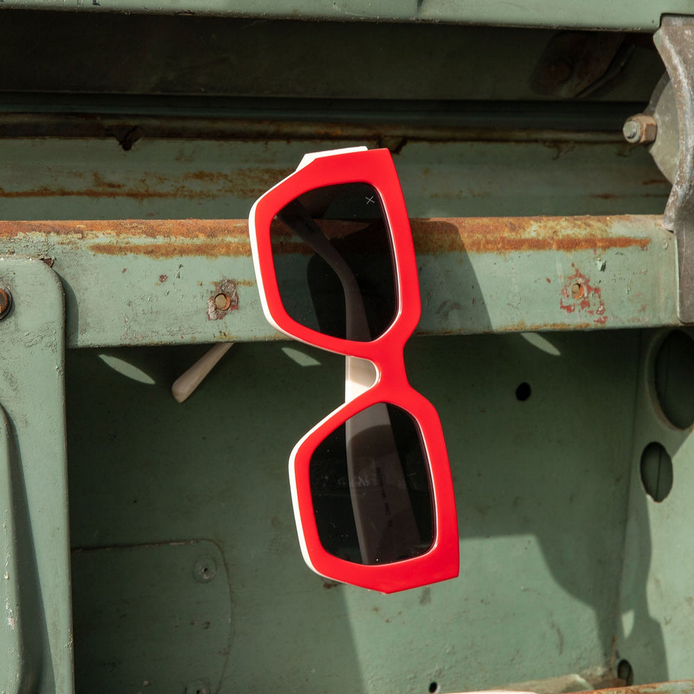 dime optics highland sunglasses with a ruby red frame hanging