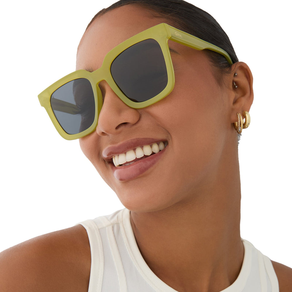on model - female wearing dime optics featuring the malibu square sunglasses with a valley green frame and grey polarized lenses angled view