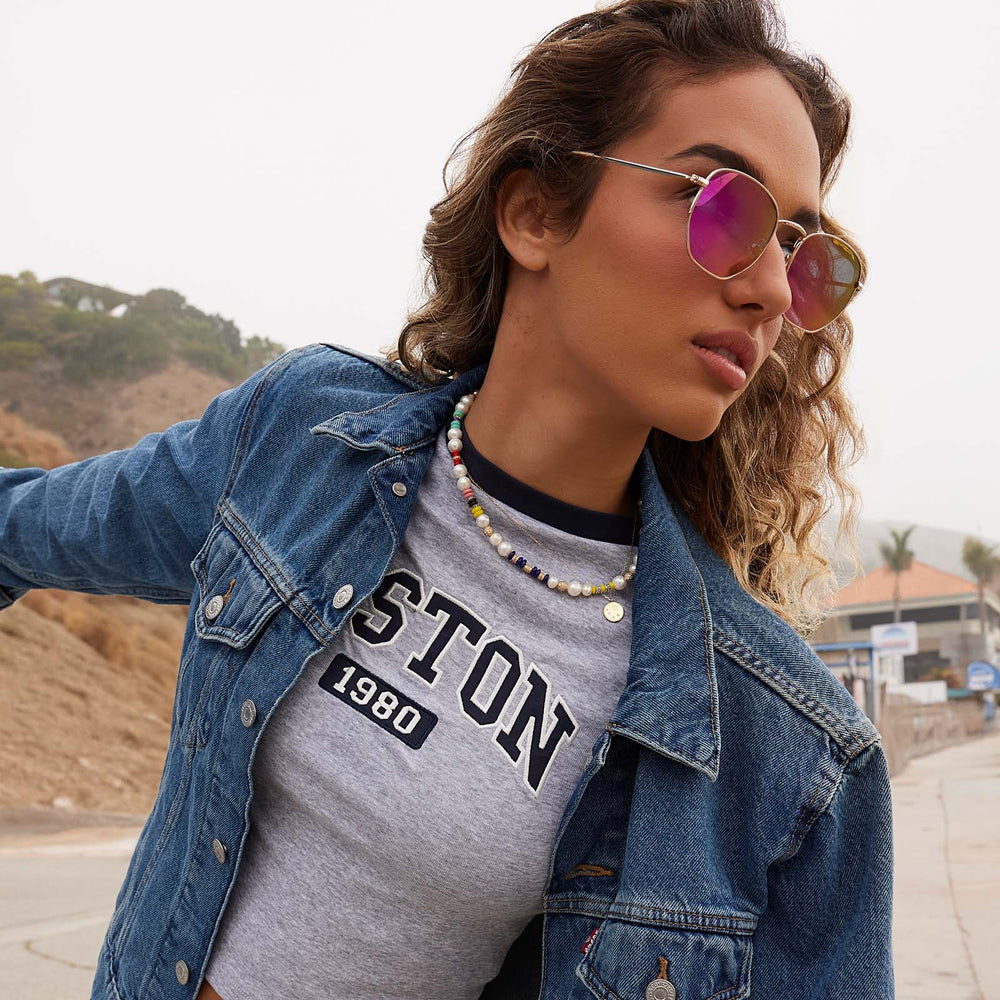 on model - female wearing dime optics roxbury round sunglasses with a gold metal frame and candy pink mirror polarized lenses side view