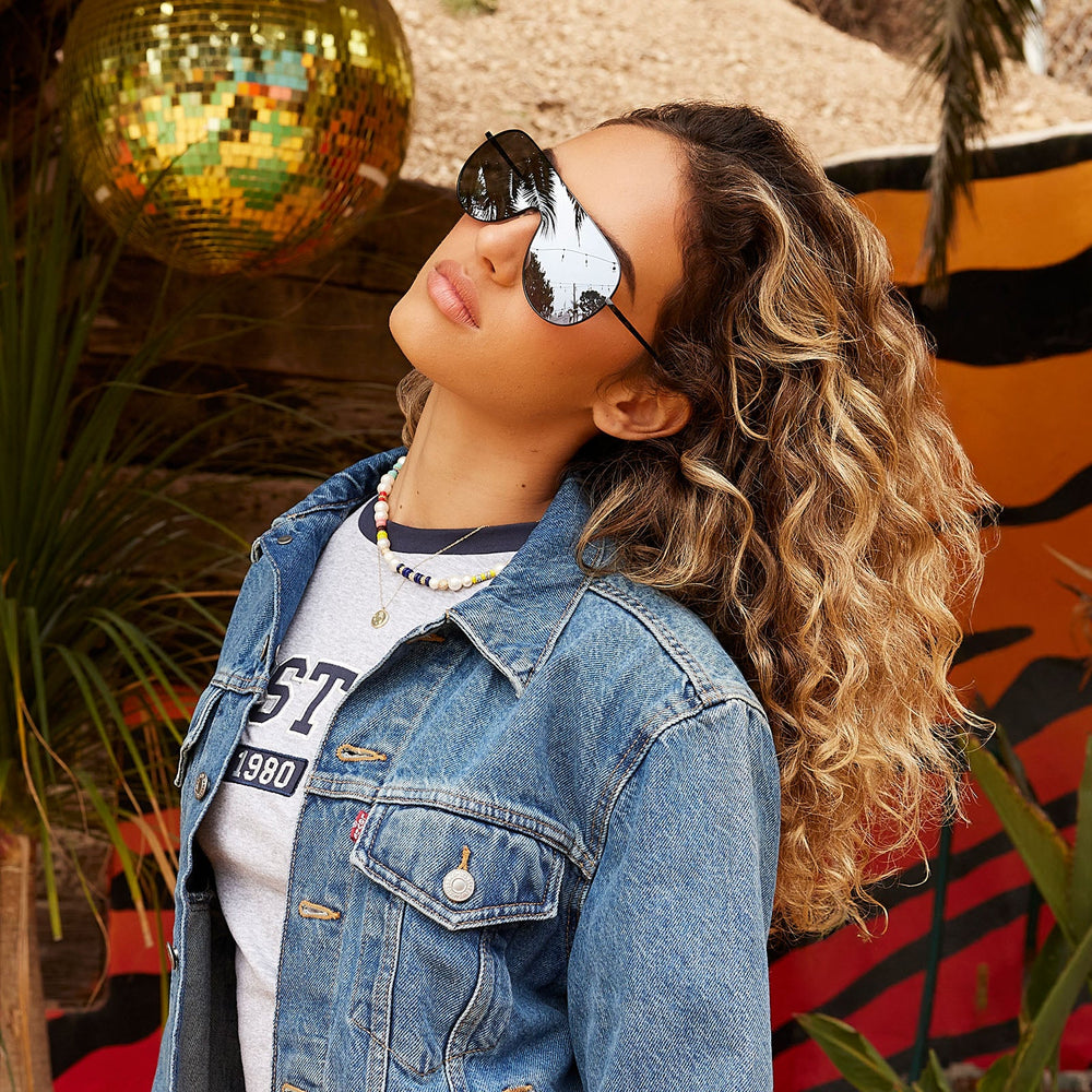 on model - female wearing dime optics tarzana shield sunglasses with a black metal frame and grey with silver flash polarized lenses angled view