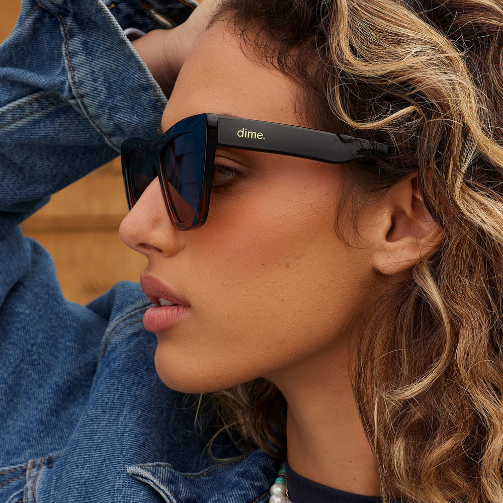 on model - female wearing dime optics featuring the windsor cat eye sunglasses with a black tortoise frame and brown polarized lenses side view