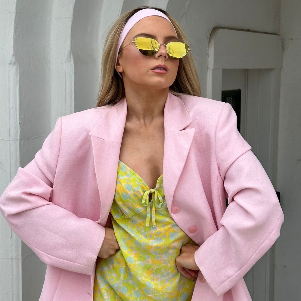 customer content- mariel higgs wearing gold sunglasses with pastel pink headband and blazer