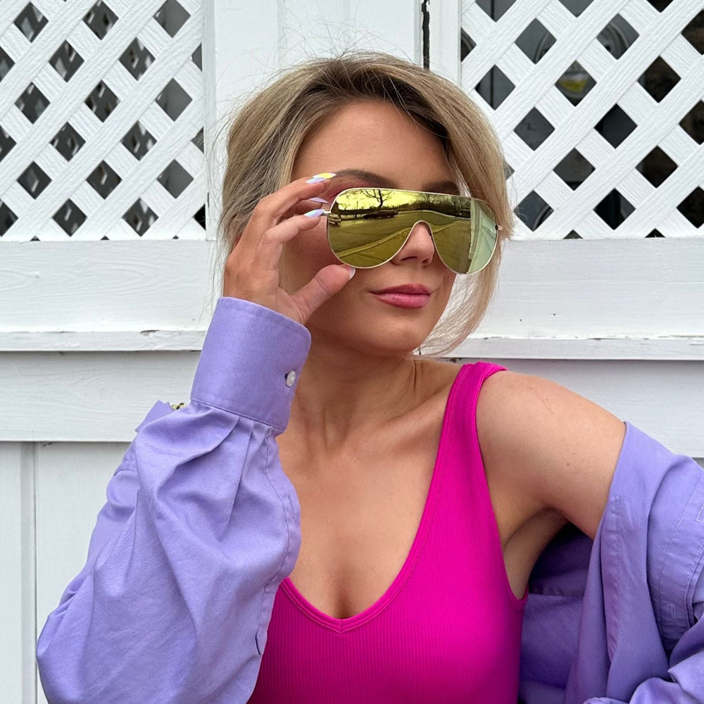 customer content - mariel higgs wearing dime optics tarzana shield sunglasses with a brushed gold metal frame and gold mirror polarized lenses front view